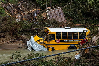 A Perry County school bus, along with other debris, sits in a creek near Jackson, Kentucky, on July, 2022. Rescuers in Kentucky are taking the search effort door-to-door in worsening weather conditions as they brace for a long and grueling effort to locate victims of flooding that devastated the state's east, its governor said.