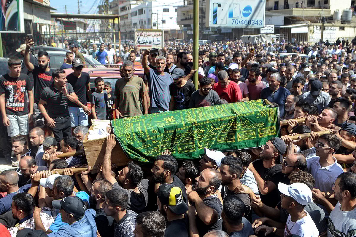 Mourners march with the body of one of the victims who drowned in the shipwreck of a migrant boat that sank off the Syrian coast, during his funeral after the return of his body in Lebanon's northern port city of Tripoli on 24 September, 2022