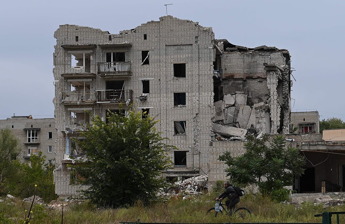 A bike rider cycles in front of a destroyed building in the city of Izium, Kramatorsk, eastern Ukraine, on 11 September, 2022, amid the Russian invasion of Ukraine