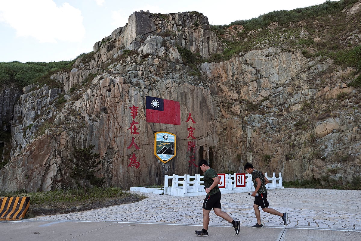 Soldiers march past a sign of the Taiwan flag on Dongyin island of Matsu archipelago in Taiwan on 15 August, 2022
