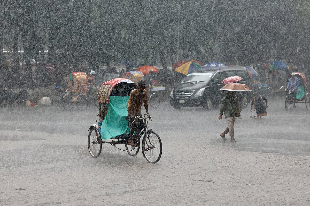 A man pulls a rickshaw during heavy rain in Dhaka