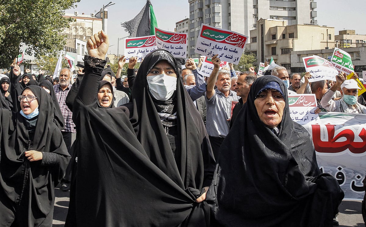 Women and men chant slogans as they march in a pro-hijab rally in Iran's capital Tehran on 23 September, 2022
