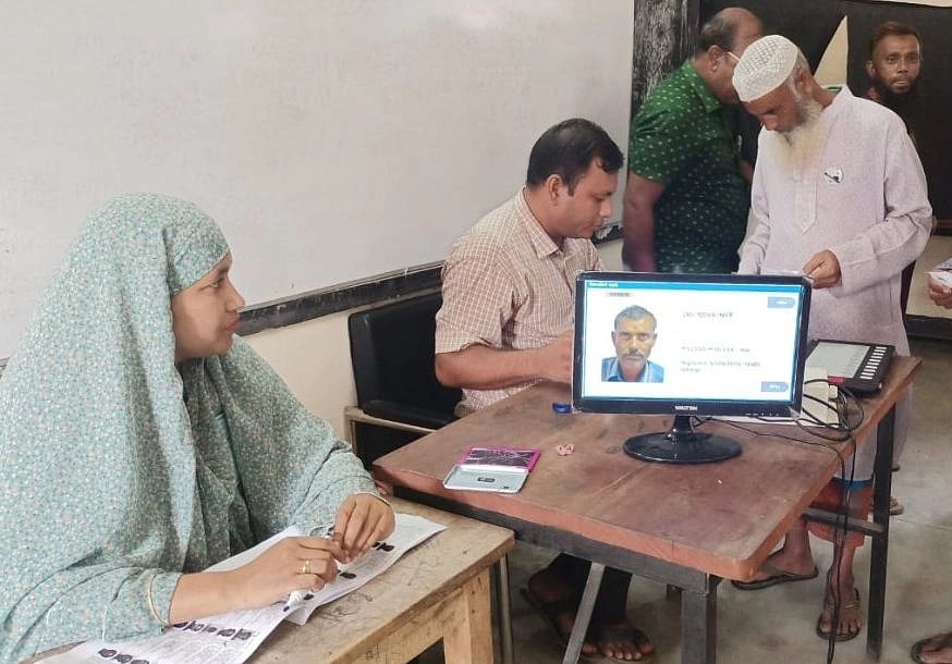 A voter (first from right) casts ballot using an electronic voting machine (EVM) at a centre during the by-election to Gaibandha-5 constituency on 12 October 2022.