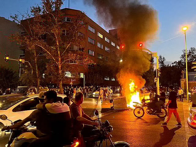 A police motorcycle burns during a protest over the death of Mahsa Amini, a woman who died after being arrested by the Islamic republic's "morality police", in Tehran, Iran on 19 September.