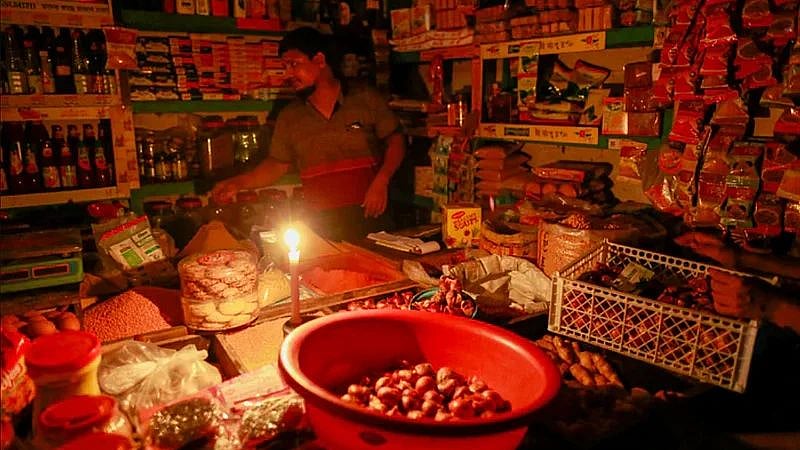 A shopkeeper doing business lighting a candle in Dhaka. The government started scheduled load shedding in Bangladesh from 19 July