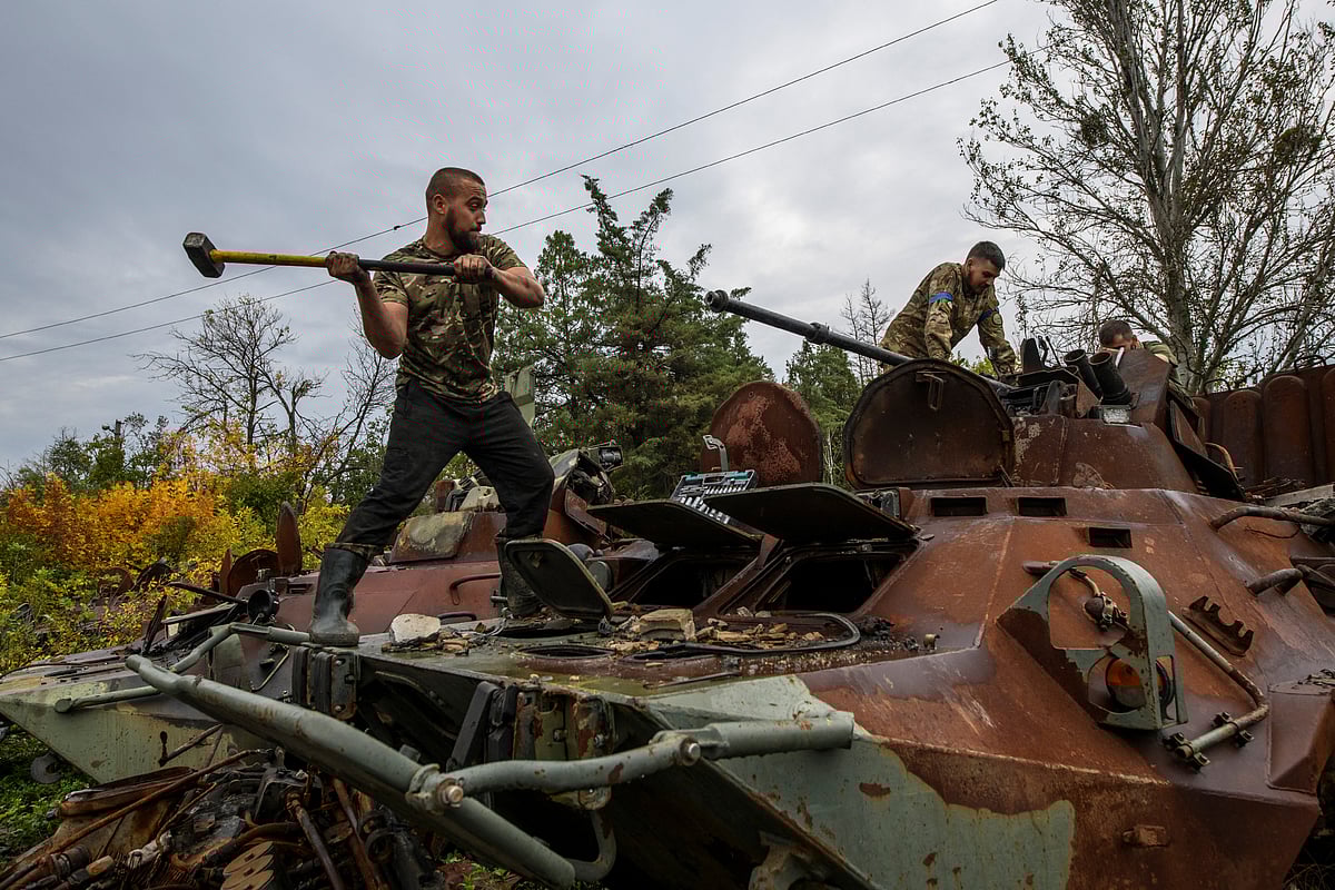 Ukrainian service member dismount a cannon from a captured Russian armoured personnel carrier, amid Russia's attack on Ukraine, near the town of Izium in Kharkiv region, Ukraine October 2, 2022