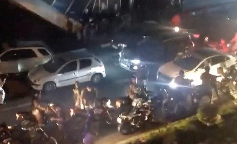 People run during clashes with riot police as students protest following the death of death of Mahsa Amini, in Tehran, Iran, Octobe, 2022, in this still image obtained from social media video