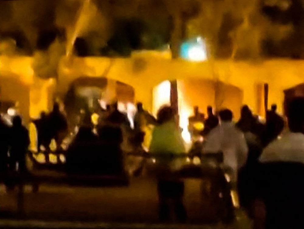 This image grab from a UGC video posted on 17 November, 2022, reportedly shows Iranian protesters starting a fire at the family home of the founder of the Islamic republic Ayatollah Ruhollah Khomeini, now a museum, in the central Iranian city of Khomein.