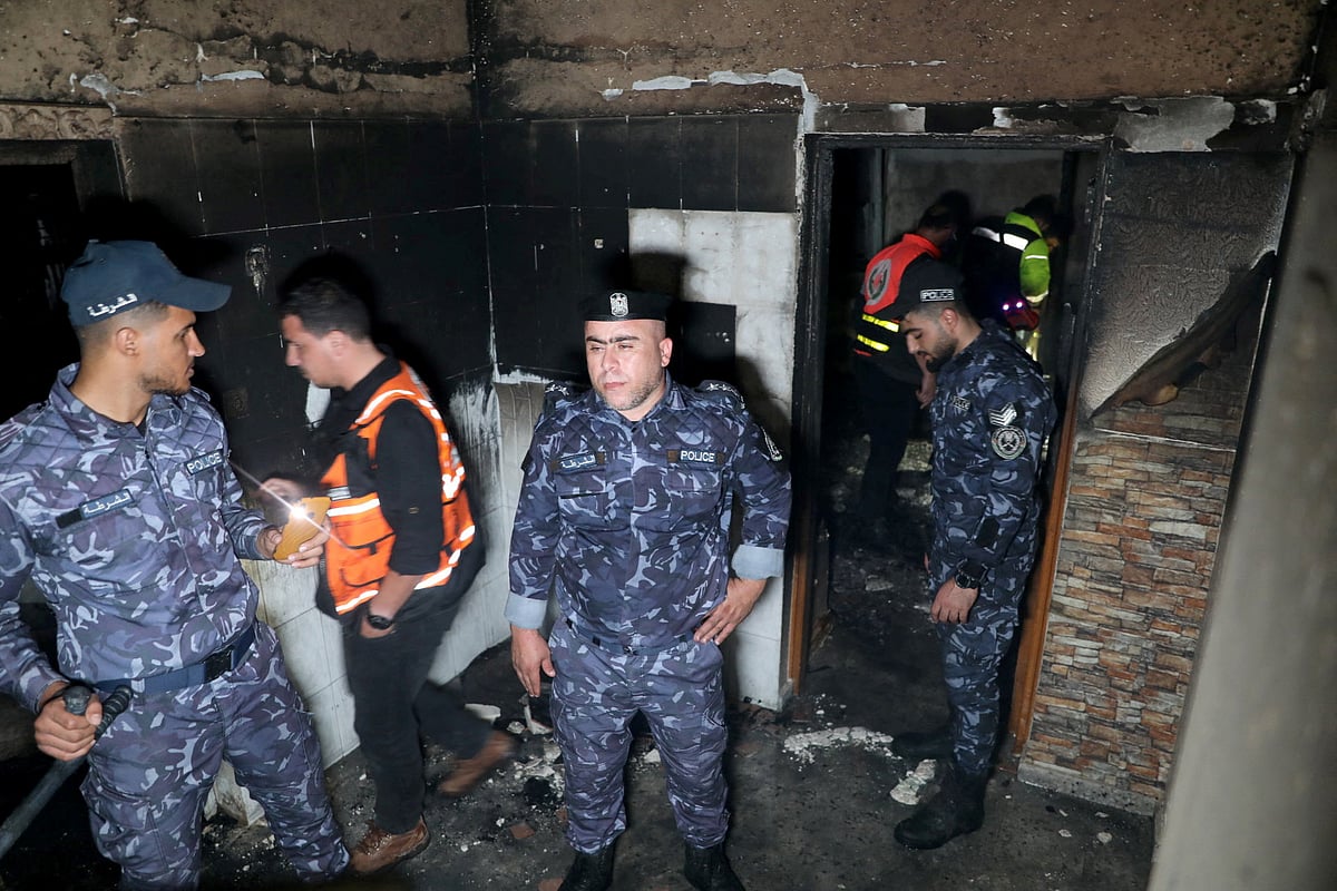 Palestinian Hamas police officers check the scene of a fire that broke out in a building where residents attended a party in the northern Gaza Strip November 17, 2022.