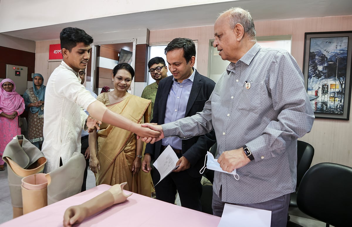 Sitakunda fire survivor with a prosthetic limb shakes hand with Samanta Lal Sen, national coordinator, Sheikh Hasina National Institute of Burn and Plastic Surgery, at an event today organised by BRAC Limb and Brace Centre at Mohammadpur, Dhaka.