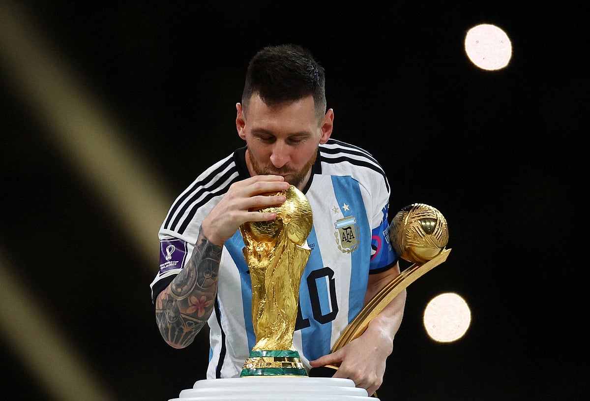 Football - FIFA World Cup Qatar 2022 - Final - Argentina v France - Lusail Stadium, Lusail, Qatar - December 18, 2022 Argentina's Lionel Messi kisses the World Cup trophy after receiving the Golden Ball award as he celebrates after winning the World Cup