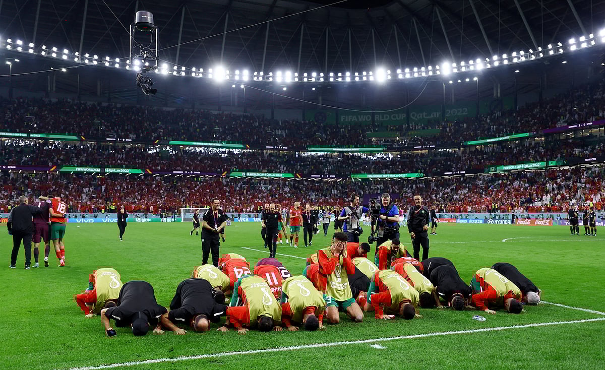 Morocco players and coaching celebrate winning the penalty shootout as Morocco progress to the quarter finals
