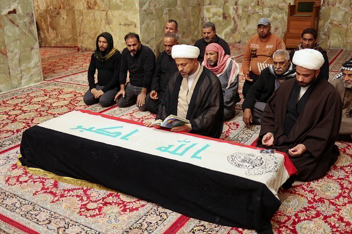Mourners pray in front of a coffin of a policeman who was killed in an attack in Kirkuk, during a funeral in Najaf, Iraq, December 18, 2022