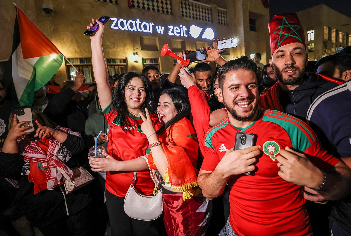 Morocco fans celebrate after their country qualified for the semifinal of the Qatar World Cup at Souq Waqif in Doha on 10 December, 2022