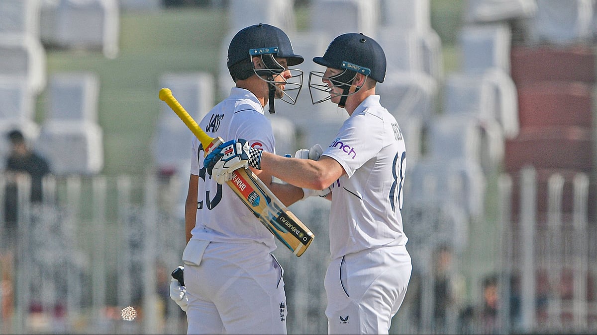England's Harry Brook (R) celebrates with teammate Liam Livingstone after scoring (150 runs) during the second day of the first Test between Pakistan and England at the Rawalpindi Cricket Stadium, in Rawalpindi on 2 December, 2022