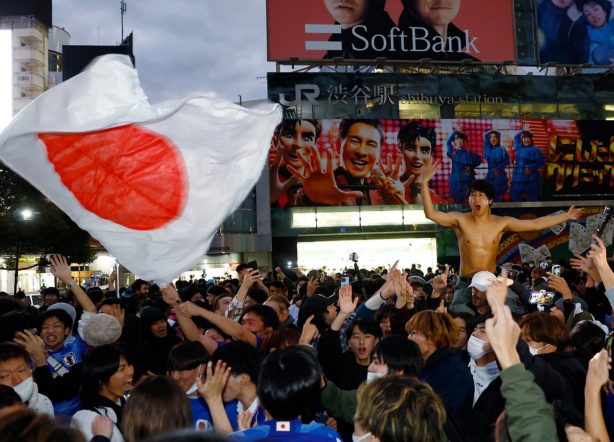 Japan fans celebrate at the Shibuya Crossing after Japan defeated Spain to qualify for the knockout stages of the FIFA World Cup 2022 in Tokyo, Japan on 2 December, 2022