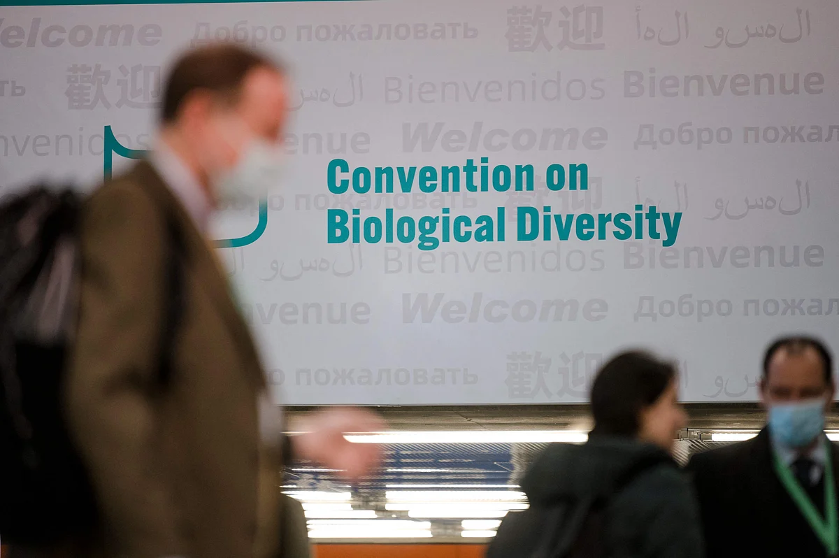 People walk in front of the convention sign at theUN Biodiversity Conference (COP15) in Montreal, Quebec, Canada, on December 17, 2022