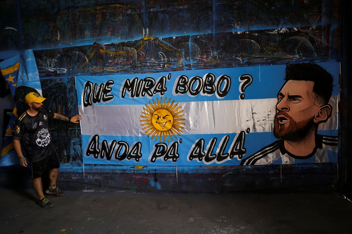 Ivan Cespol, who works at Argentine flag painting business "Serigrafia del Oeste", paints a flag with a portrait of soccer star Lionel Messi that reads in Spanish "What are you looking at, fool? Go Away"