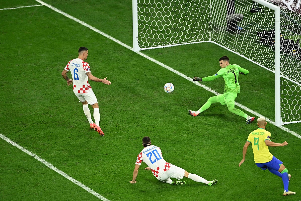 Croatia's goalkeeper Dominik Livakovic saves a goal past Brazil's forward Richarlison