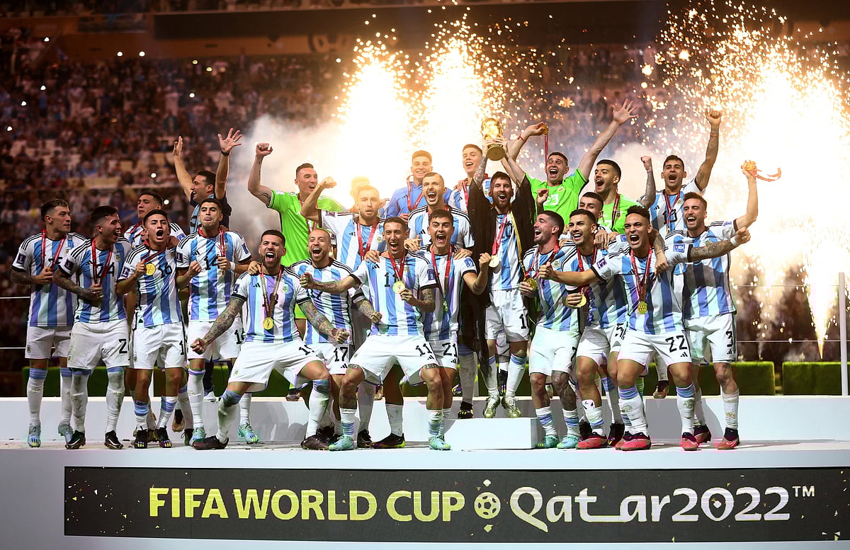 Argentina's Lionel Messi celebrates with the trophy and teammates after winning the World Cup