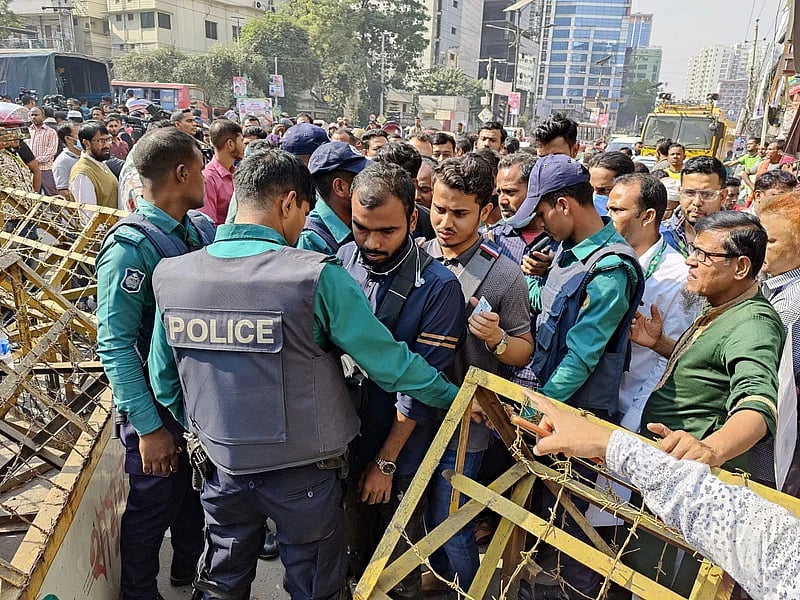 Police check ID cards before allowing people to enter the road in front of the BNP Office in Naya Paltan, Dhaka, on 8 December 2022