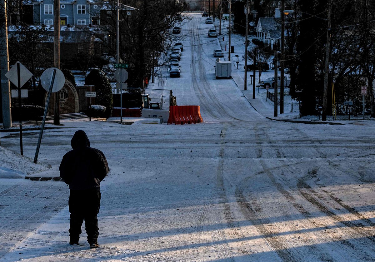 A Nashville resident walks to work on 23 December, 2022, after winter storm Elliot moved through the Middle Tennessee region through the night leaving behind freezing rain, snow and below freezing temperatures, in Nashville, Tennessee. A historic and brutal winter storm put some 240 million Americans under severe weather warnings Friday as the US faced holiday travel chaos, with thousands of flights cancelled and major highways closed.