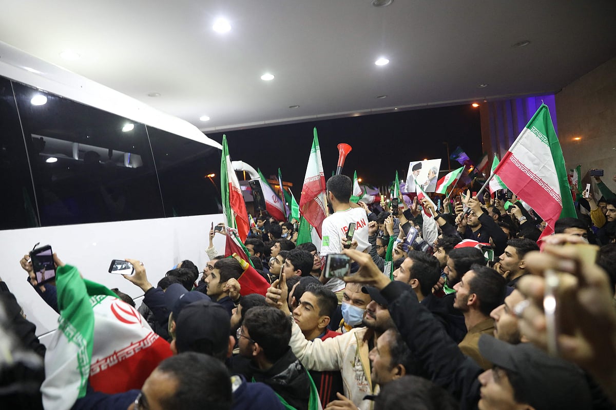 Iran fans wave flags as they gather at Imam Khomeini Airport in Tehran on December 1, 2022 to greet the Iranian national team upon their return after competing in the Qatar 2022 World Cup. The United States beat Iran 1-0 to reach the knockout phase of the World Cup on November 29