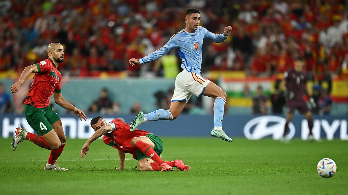 Spain's Ferran Torres in action with Morocco's Romain Saiss and Sofyan Amrabat