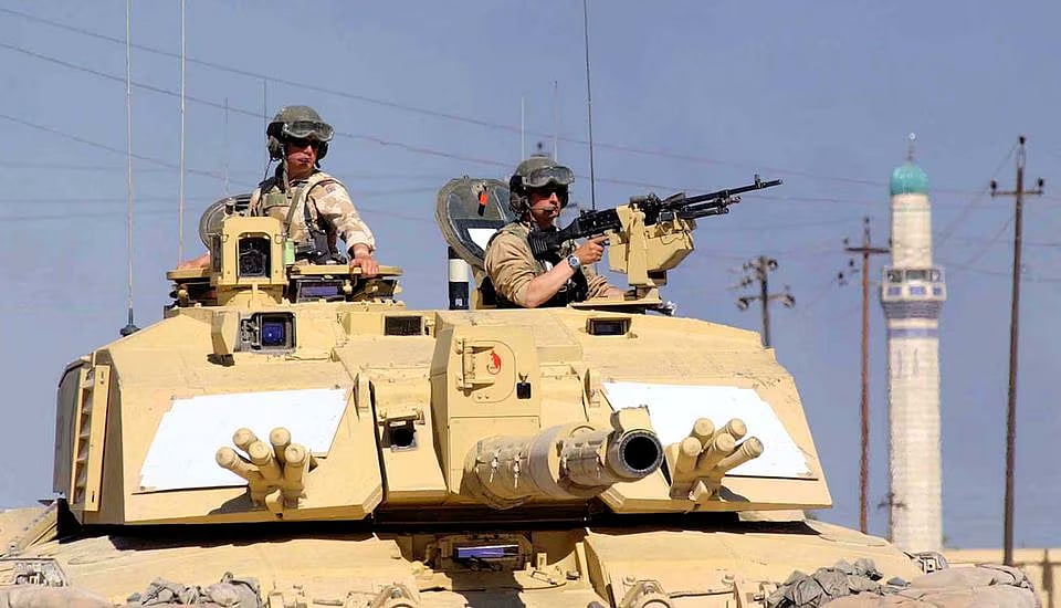 British Sergeant Steve Guy (L) and Corporal Andy Porter keep watch out of a Challenger 2 tank from the 2nd Royal Tank Regiment on patrol in southern Iraq, 2 April, 2003.