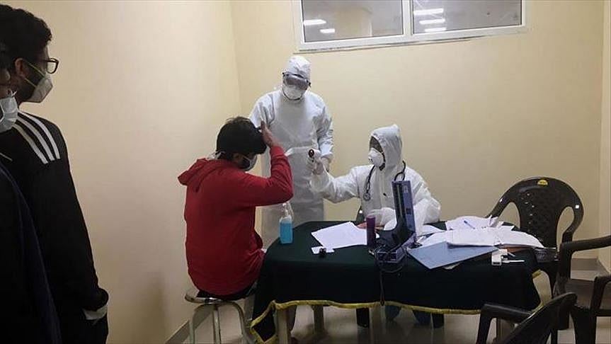 Health workers collect samples from a person for Covid test
