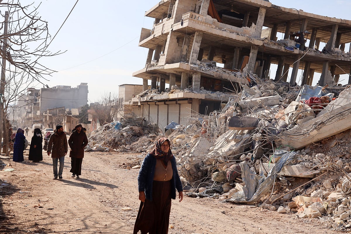 Residents walk along destroyed buildings, as search and rescue operations continue days after a deadly earthquake hit Turkey and Syria, in the town of Jindayris, in the rebel-held part of Syria's Aleppo province, on 10 February, 2023
