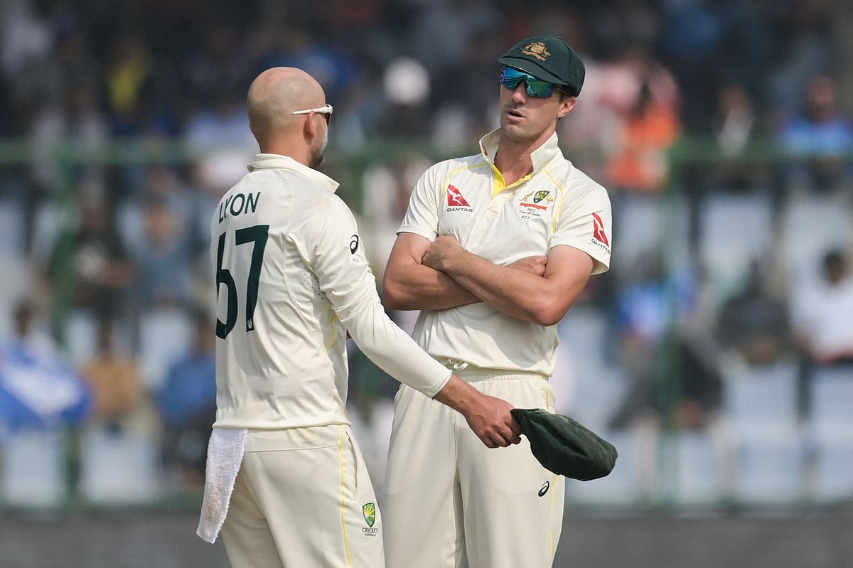 Australia's captain Pat Cummins speaks with Nathan Lyon
