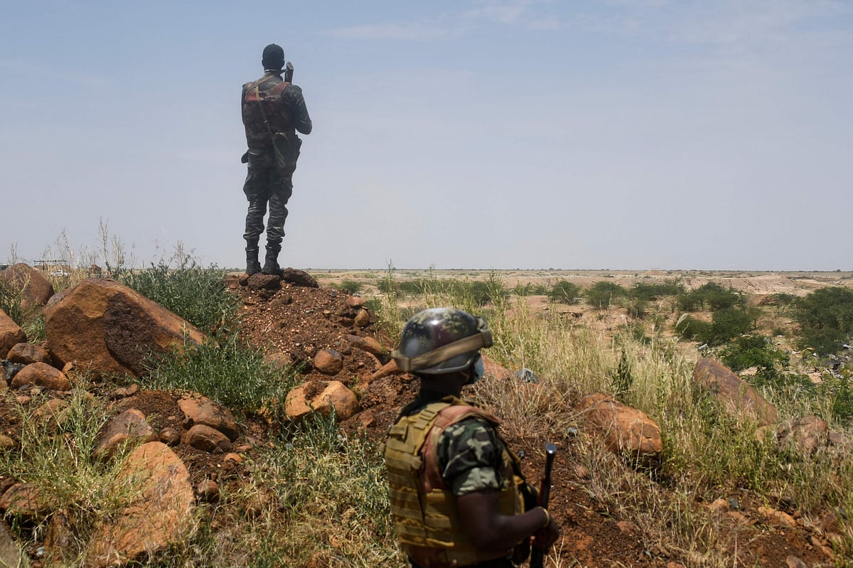 In this file photo taken on 10 September, 2021 Niger's soldiers stand guard and patrol near the construction site of the first dam that the country builds on the Niger river near the village of Kandadji