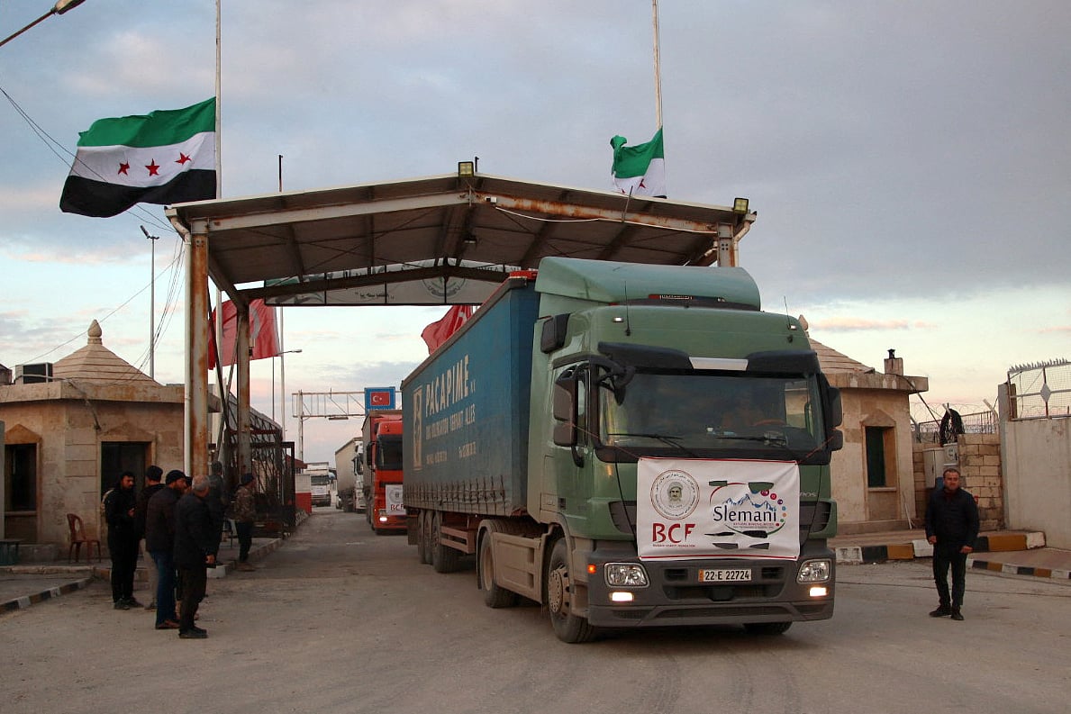 A convoy of trucks carrying humanitarian aid to earthquake victims, sent by a Kurdish charity organisation, enters Syria through the opposition-held Bab al-Salama crossing with Turkey in the northern Aleppo province on 10 February 2023.