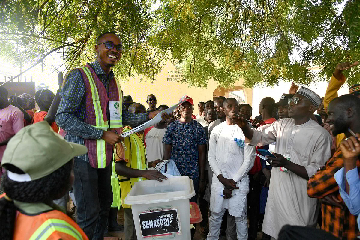 An Independent National Electoral Commission (INEC) official holds up a ballot paper towards part agents during the counting process at a polling station in Yola on 25 February, 2023