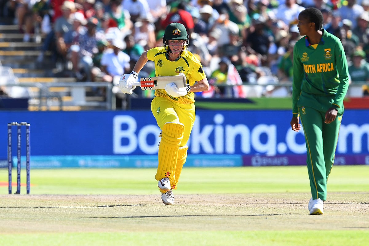Australia's Beth Mooney (L) runs between the wickets as South Africa's Ayabonga Khaka (R) looks on during the final T20 women's World Cup cricket match between South Africa and Australia at Newlands Stadium in Cape Town on February 26, 2023