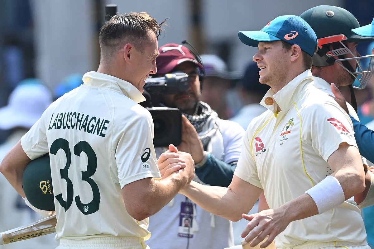 Australia's captain Steve Smith celebrates with Australia's Marnus Labuschagne after winning during the third day of the third Test between India and Australia at the Holkar Stadium in Indore on 3 March 2023