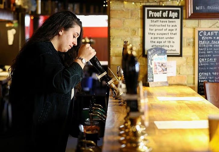 A barmaid pours a pint at a pub in Cambridge, Britain, on 24 January, 2023.