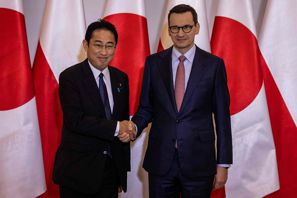 Japan’s Prime Minister Fumio Kishida (L) and his Polish counterpart Mateusz Morawiecki shake hands prior to a meeting in Warsaw, on 22 March, 2023