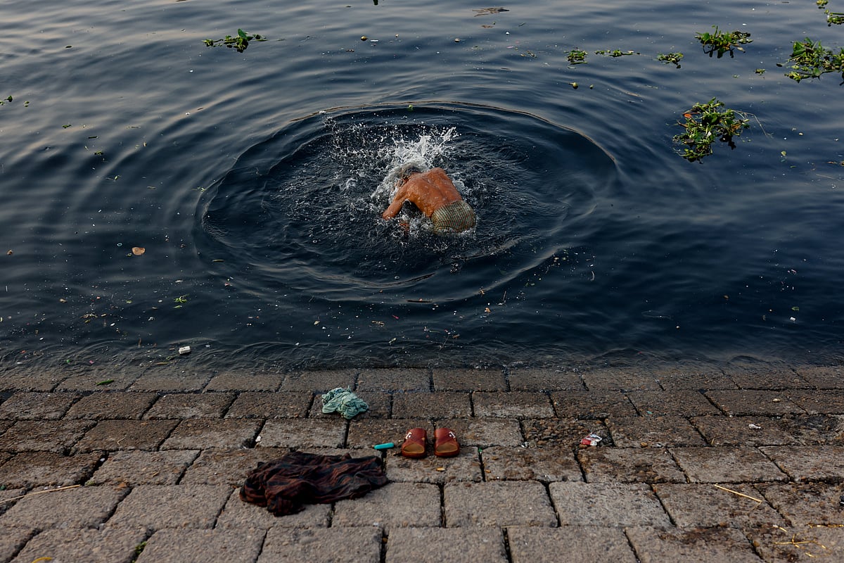 Day labourer Motahar Hossain, 65, takes a bath in the polluted water of the Buriganga river in Dhaka, Bangladesh. 6 March, 2023