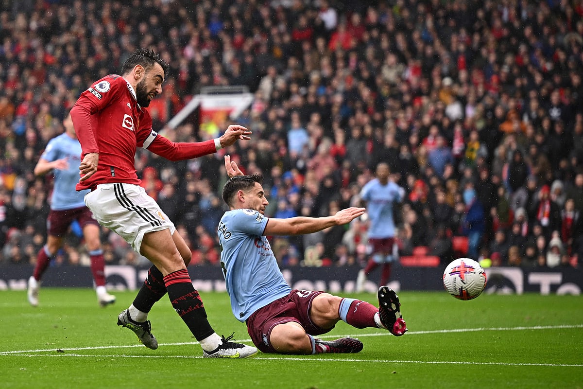 Manchester United's Portuguese midfielder Bruno Fernandes (L) shoots and scores his team first goal during the English Premier League football match between Manchester United and Aston Villa at Old Trafford in Manchester, north west England, on April 30, 2023