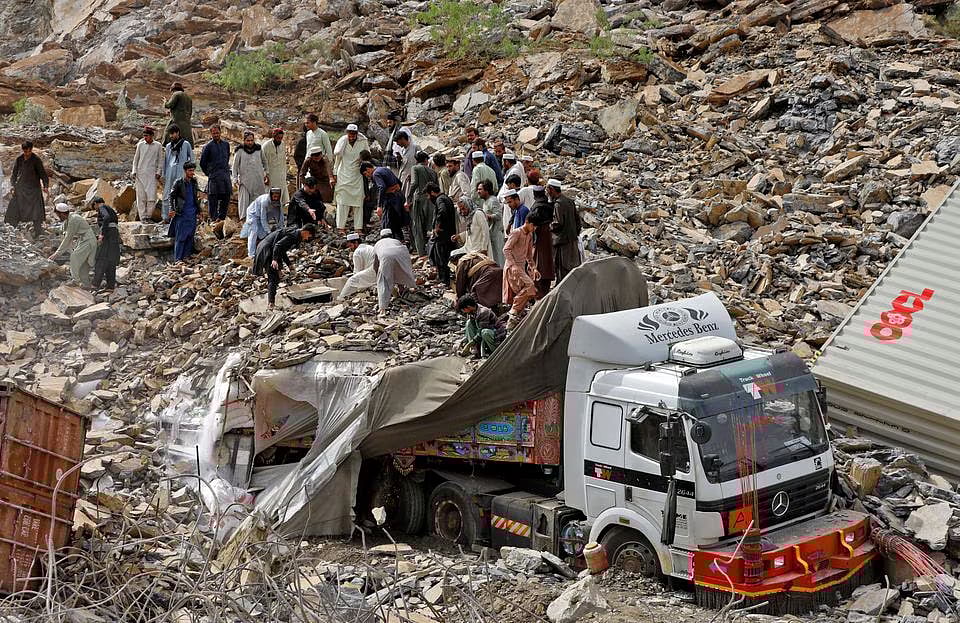 People search for survivors next to a damaged supply vehicle after a landslide close to the Torkham border, Pakistan, on 18 April, 2023.
