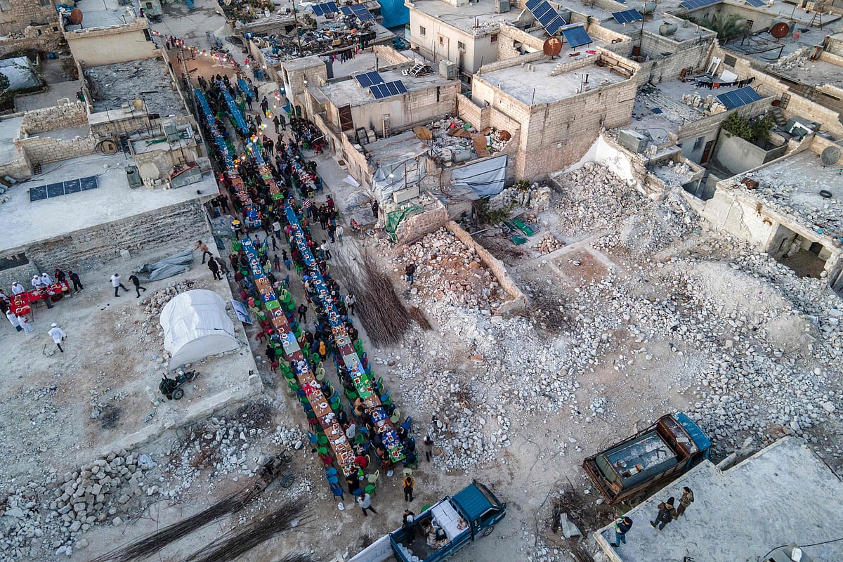This aerial view shows locals affected by the February 6 earthquake attending a mass "Iftar" fast-breaking dinner in the town of Atareb in the rebel-held western countryside of Aleppo province, on March 31, 2023 at the end of the fasting day during the Muslim holy month of Ramadan