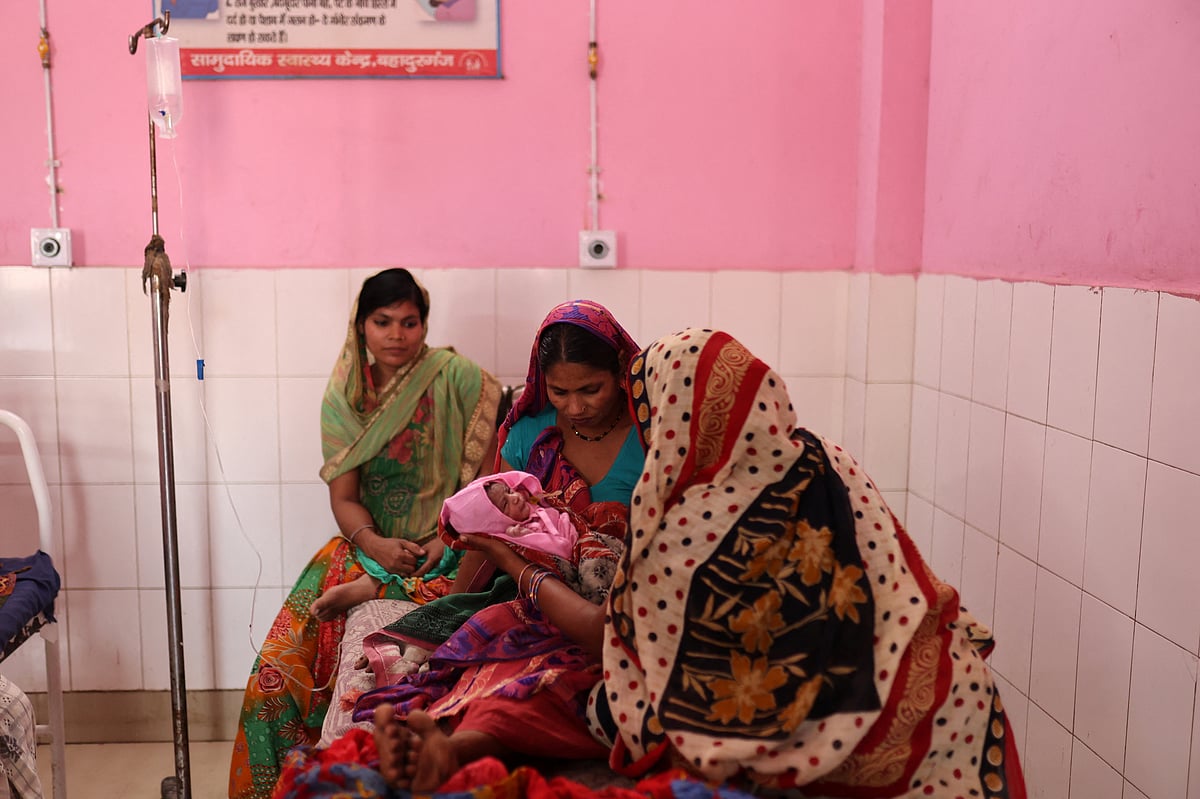 Zamerun Nisha, 33, holds her newborn baby as her sister Sanerum, 38, and her sister-in-law Zabinad, 15, keep her company at the maternity ward of a community health centre in Bahadurganj subdivision of Kishanganj district, in the state of Bihar, India, March 21, 2023