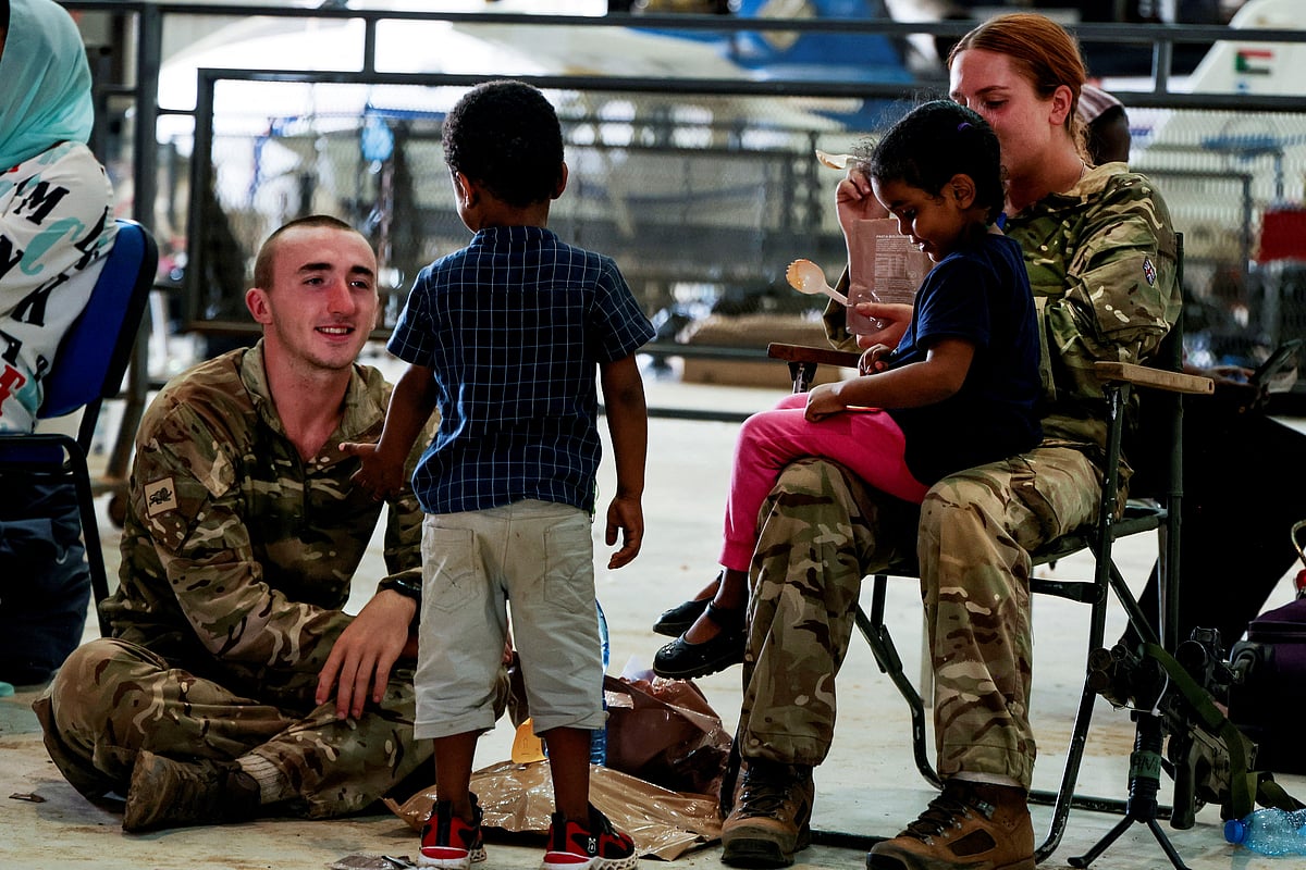 British Army Duke of Lancaster's Regiment members look after children at Wadi Seidna Air Base in Sudan April 28, 2023 in this handout image