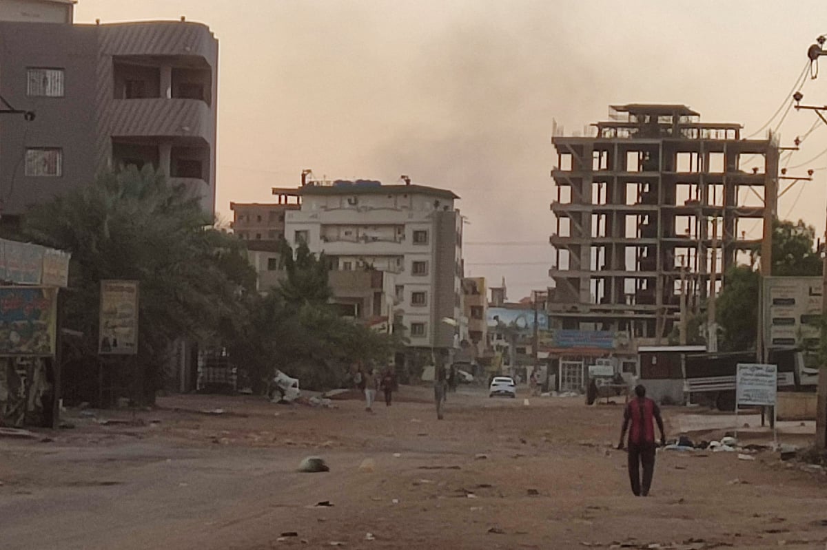 People walk on an almost empty street in southern Khartoum, on May 2, 2023