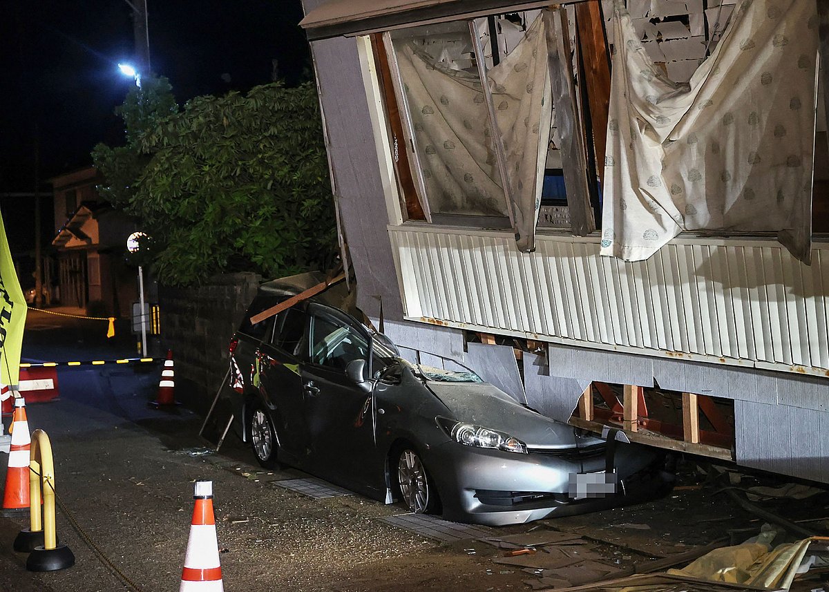 A car crushed by a collapsed house is pictured in the city of Suzu, Ishikawa prefecture early on 6 May, 2023, after a 6.5 magnitude earthquake hit the area the day before.