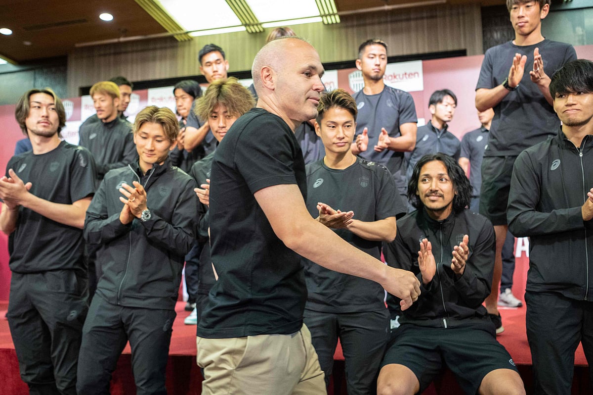 Spanish footballer Andres Iniesta (C), former Barcelona star and a present midfielder with Japanese club Vissel Kobe, is applauded by teammates at the end of a press conference in Kobe on 25 May, 2023