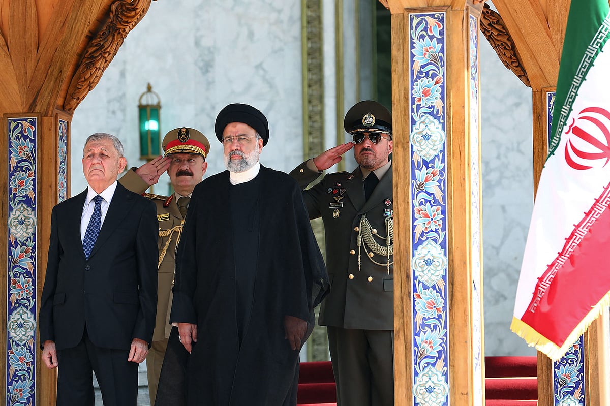 A handout picture provided by the Iranian presidency on on April 29, 2023, shows Iran's President Ebrahim Raisi (L) welcoming his Iraqi counterpart Abdul Latif Rashid in Tehran