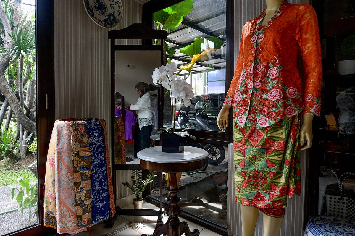 In this picture taken on 14 April, 2023, an employee works at a store selling traditional kebaya in Jakarta. Malaysia, Indonesia, Singapore, Brunei and Thailand jointly nominated kebayas for the UNESCO intangible cultural heritage list, with the decision expected in late 2024.